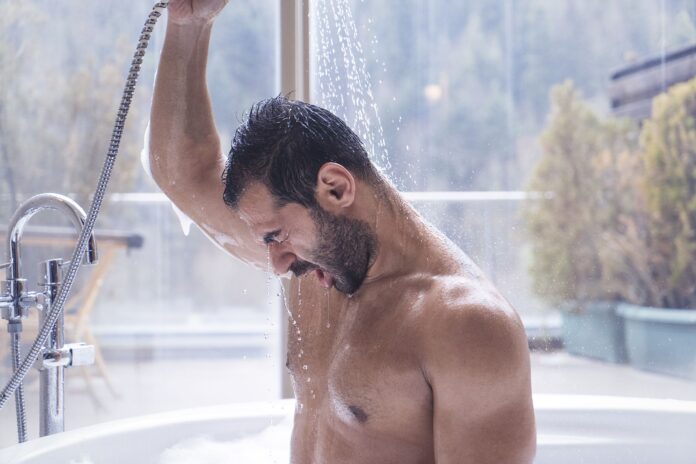 man-having-shower-in-a-hot-tub-with-a-forest-view-royalty-free-image-1686316758